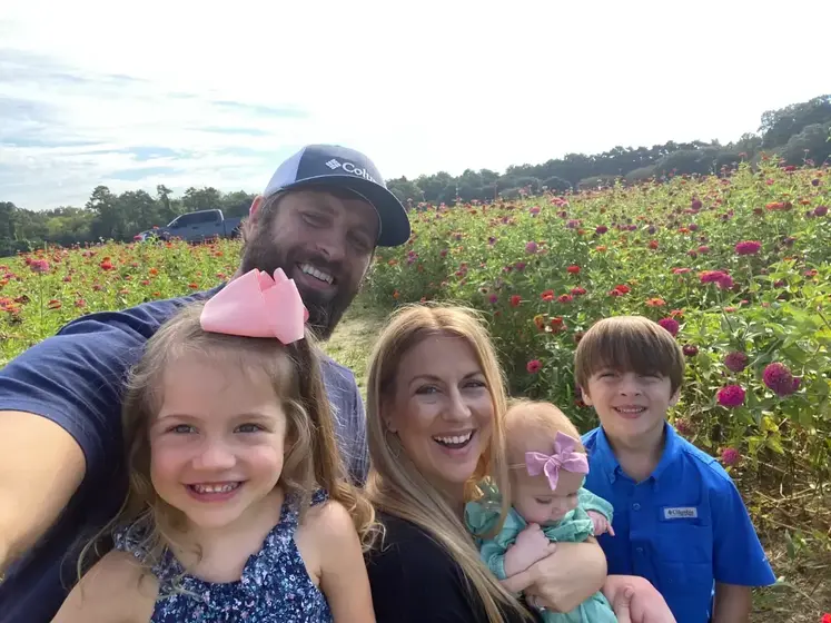 Breigh, Adam and their three children in a field of flowers