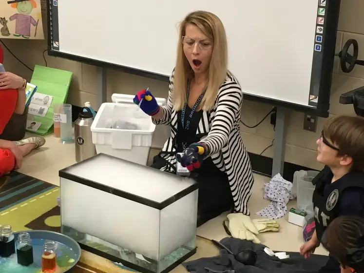 Breigh demonstrating dry ice to a class of students